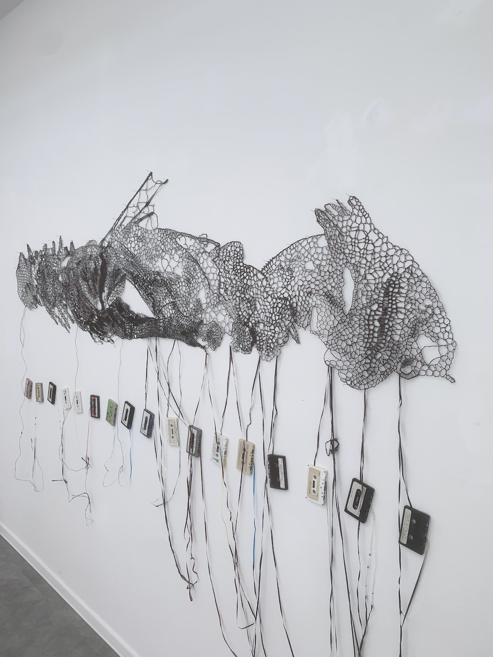 Pierre Fouché. Privy to Mysteries. 2024. Cassette Tapes of discarded religious sermons. 2.5 x 0.8m (main panel - installation dimensions variable).